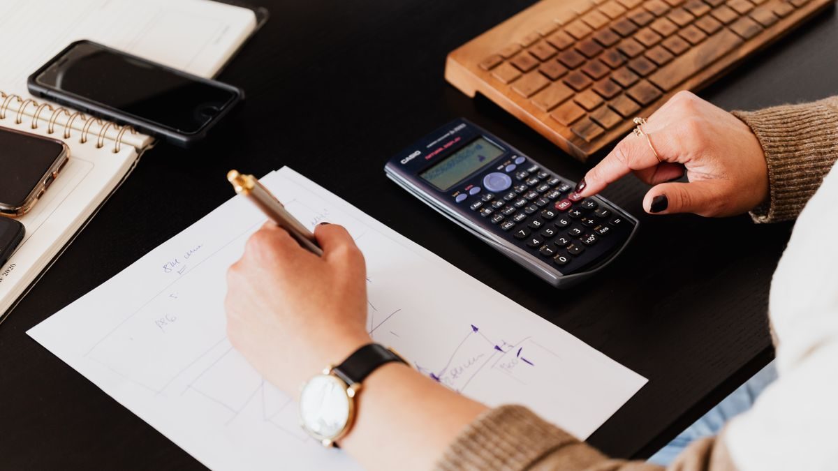Escritorio con calculadora y anotaciones de cuentas corrientes